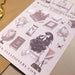 Sheet of decorative stickers with a girl, books, and vintage items on a beige surface.
